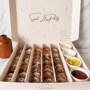 Box of mini pancakes with assorted toppings