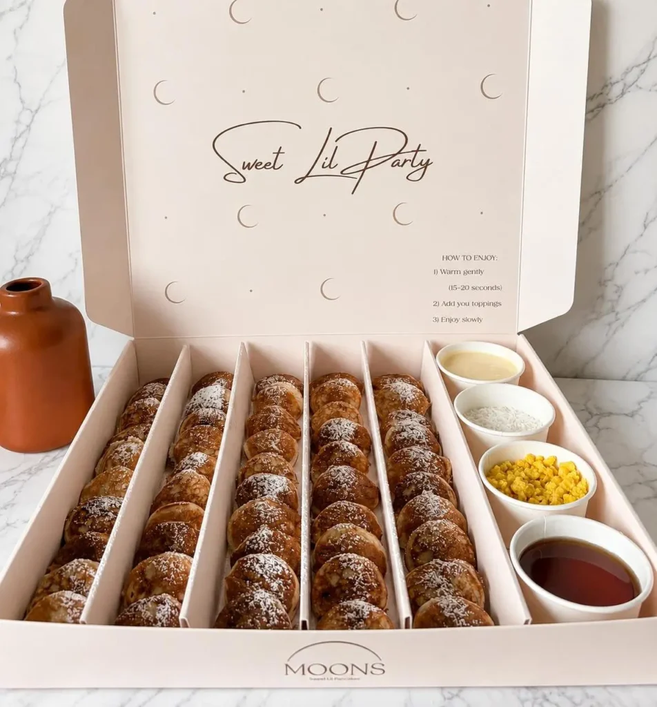 Box of mini pancakes with assorted toppings