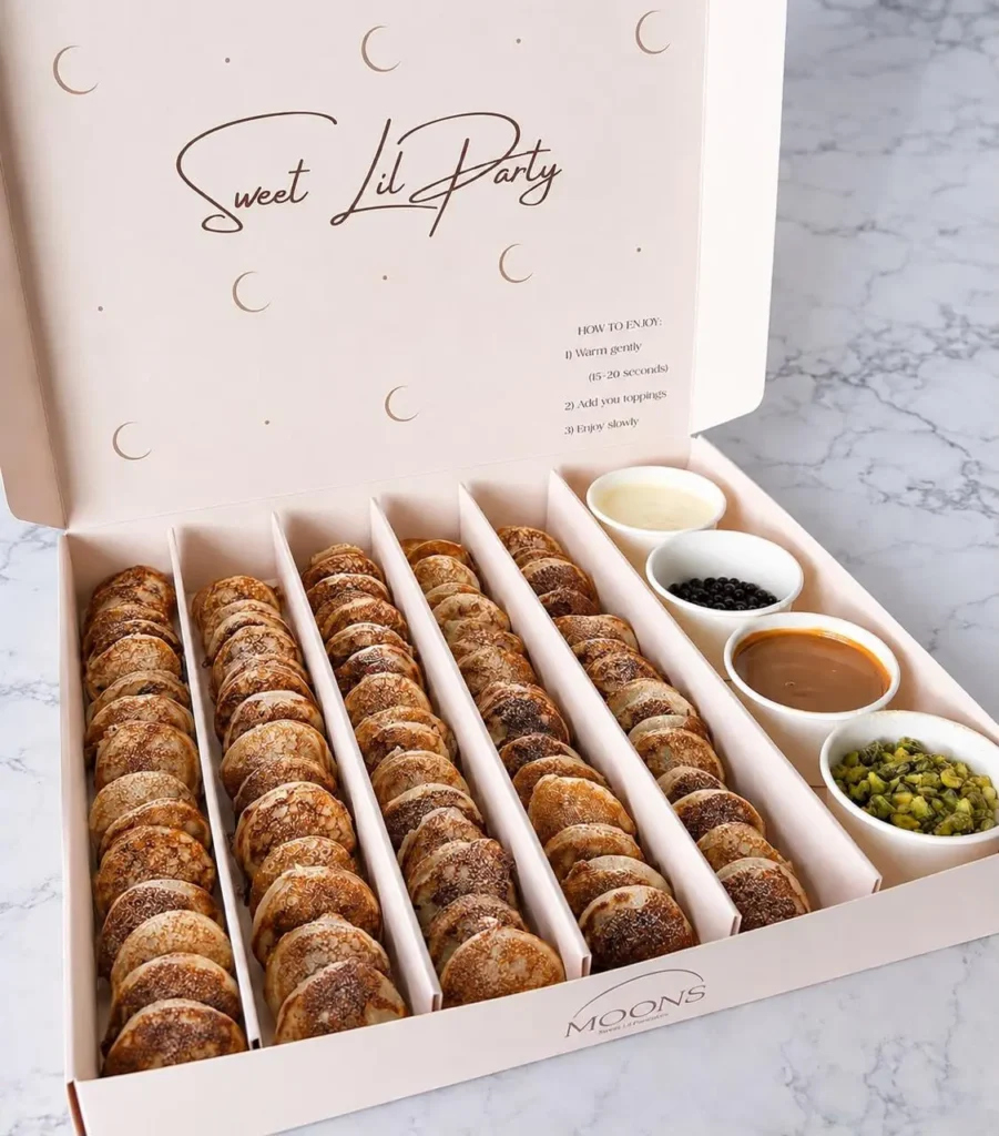 Box of mini pancakes with assorted toppings